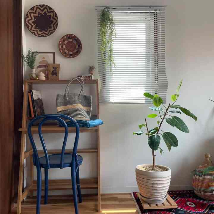 白い壁と木目調家具のナチュラルな空間、青い椅子と赤いペルシャ絨毯が印象的なインテリア