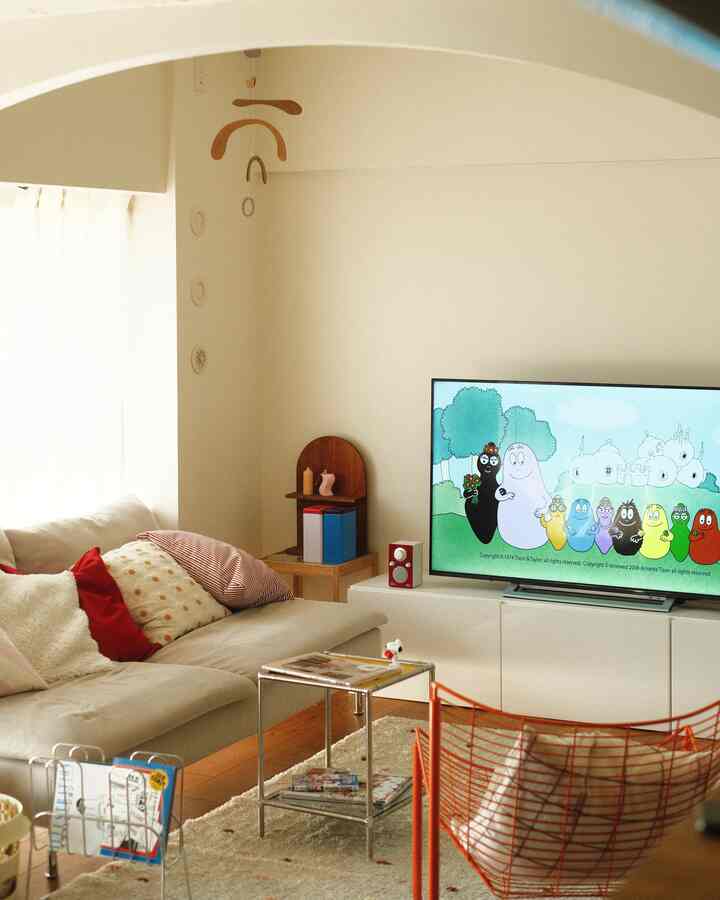 白とベージュの色調のリビング、ソファとテレビが配置されたシンプルモダンなインテリア