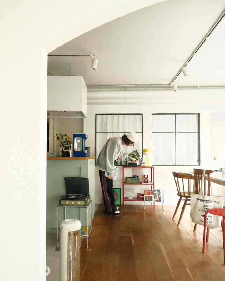 白と木目調の調和が美しい円形の子供部屋、レトロなレコードプレーヤーと赤い収納棚が配置されたミニマルでナチュラルなインテリア