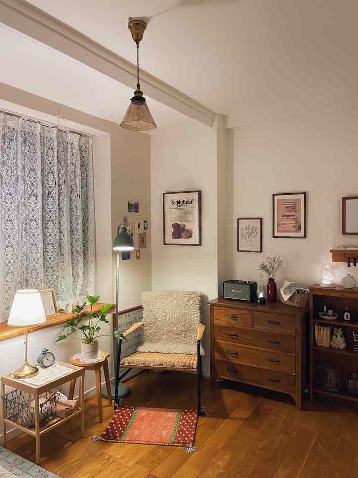 暖かみのあるブラウンとホワイトのリビング、アームチェアとサイドテーブル、フロアランプが配された雰囲気のある読書空間