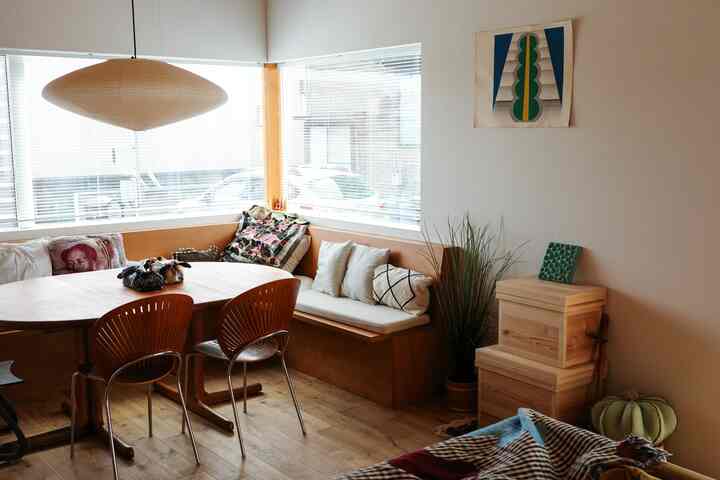 ナチュラルウッドトーンのダイニング、コーナーに大きなベンチとダイニングチェアが配置された落ち着いた空間