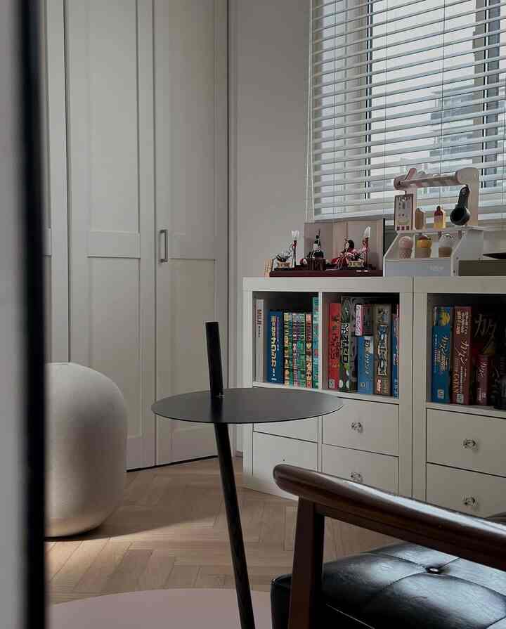 白と黒のトーンの子供部屋、白い本棚にボードゲームやおもちゃが整然と配置された印象的な空間