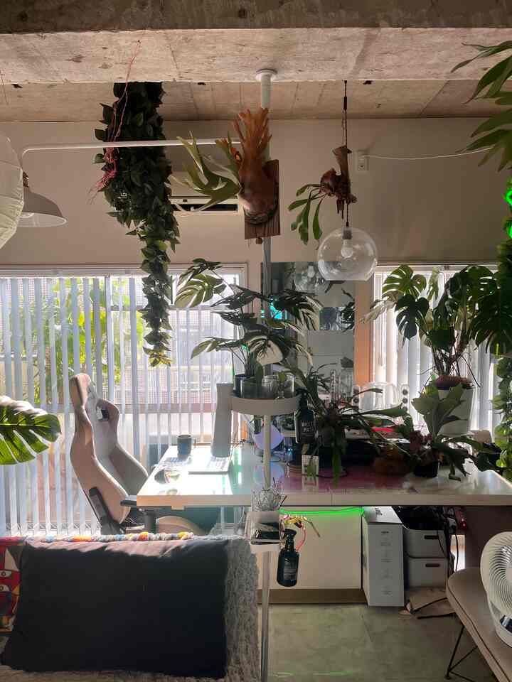 白とナチュラルカラーのホームオフィス、植物やゲーミングチェアが配置された落ち着いた雰囲気のインテリア