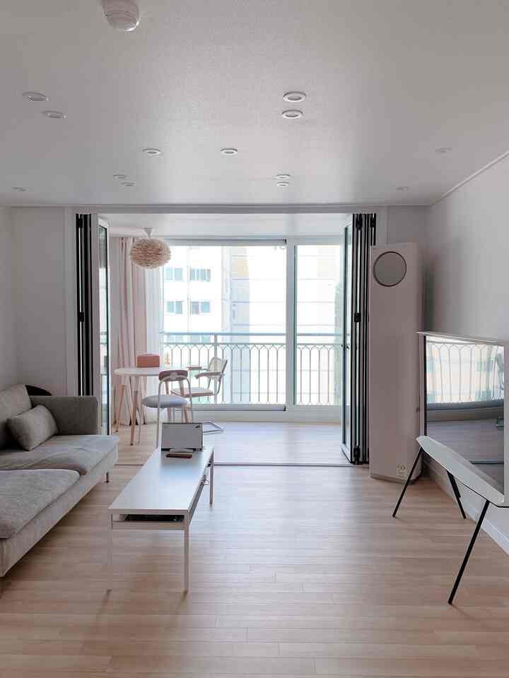 White and wood tones blend in a natural modern living room with extended veranda and home cafe corner
