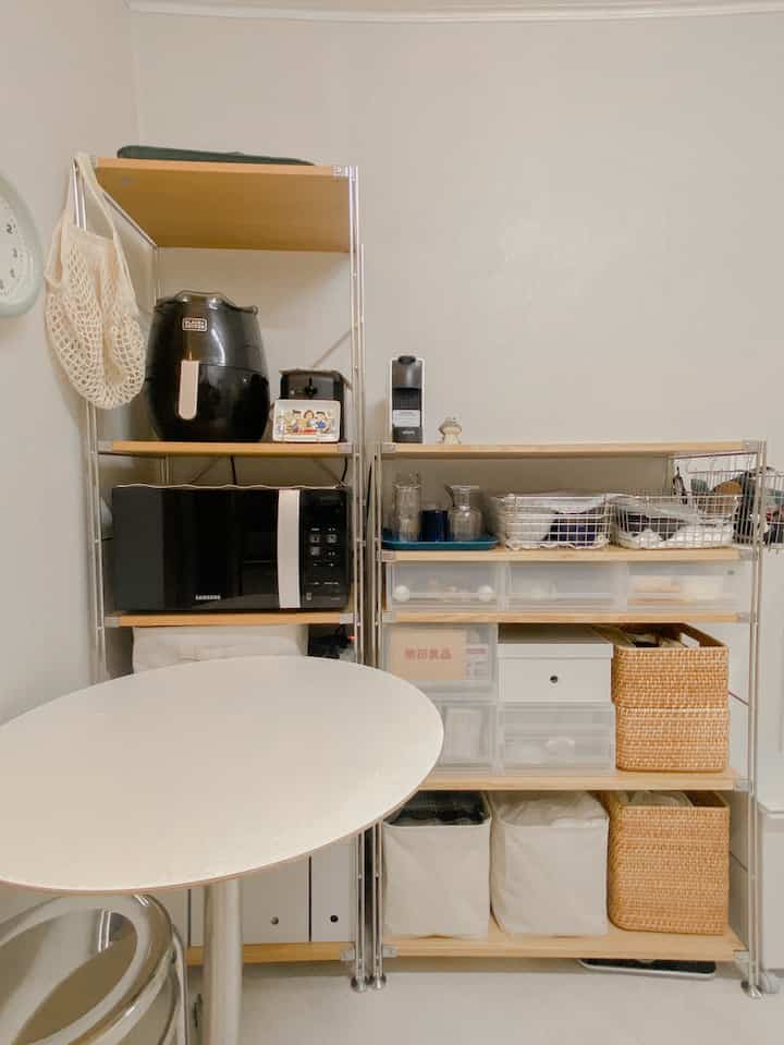 Natural wood shelves and white walls in a small apartment kitchen, featuring tidy storage ideas and a compact, practical layout
