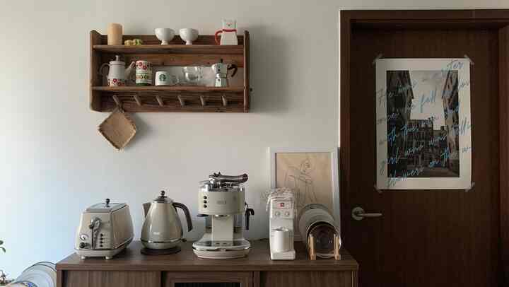 Natural wood tones and vintage appliances dominate this kitchen with neatly arranged coffee equipment, creating a warm and cozy atmosphere
