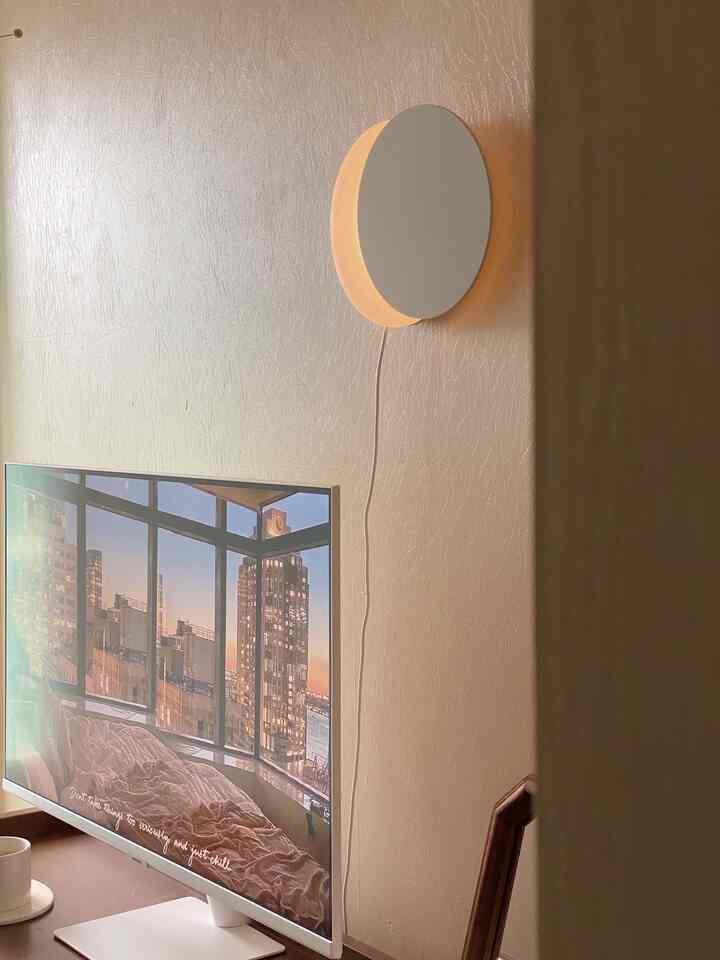 柔らかいホワイトトーンの壁と月のムードライトが配置された落ち着いたモダンな空間