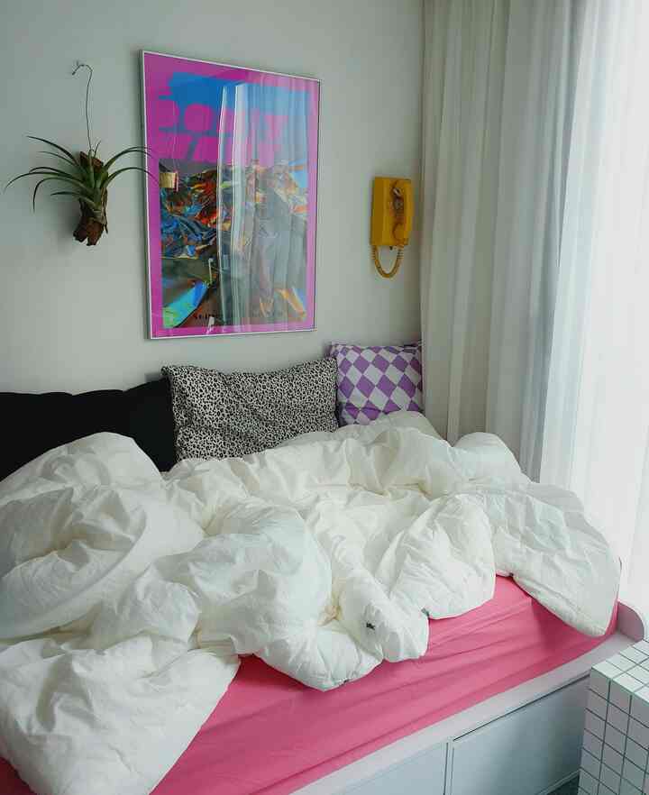 White and pink toned bedroom featuring bed with duvet cover in cozy setting