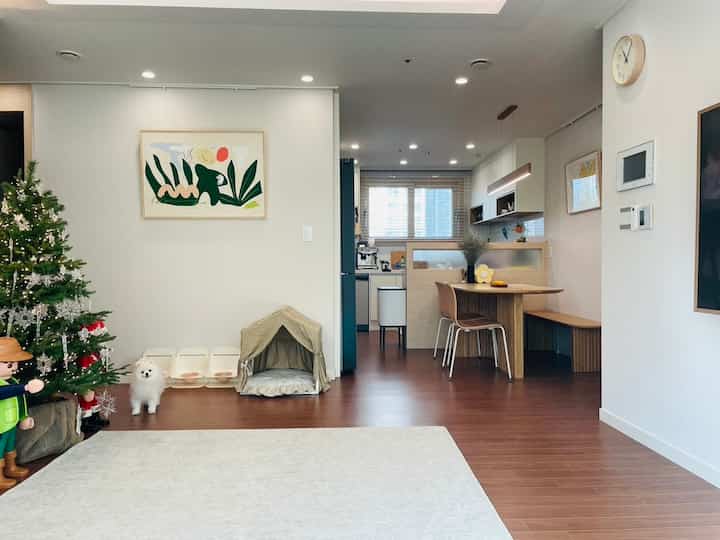Natural-toned kitchen and dining area in white and brown, featuring pet space and cozy atmosphere