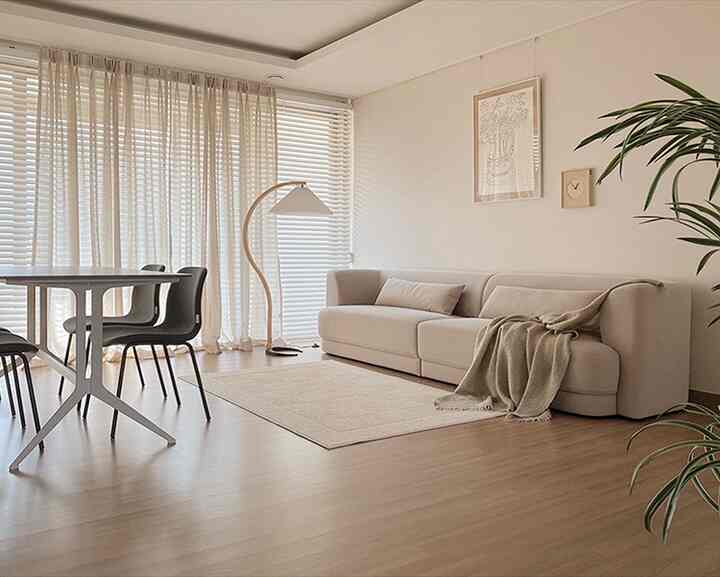 Warm beige tone living and dining area featuring clean layout with natural modern furniture arrangement