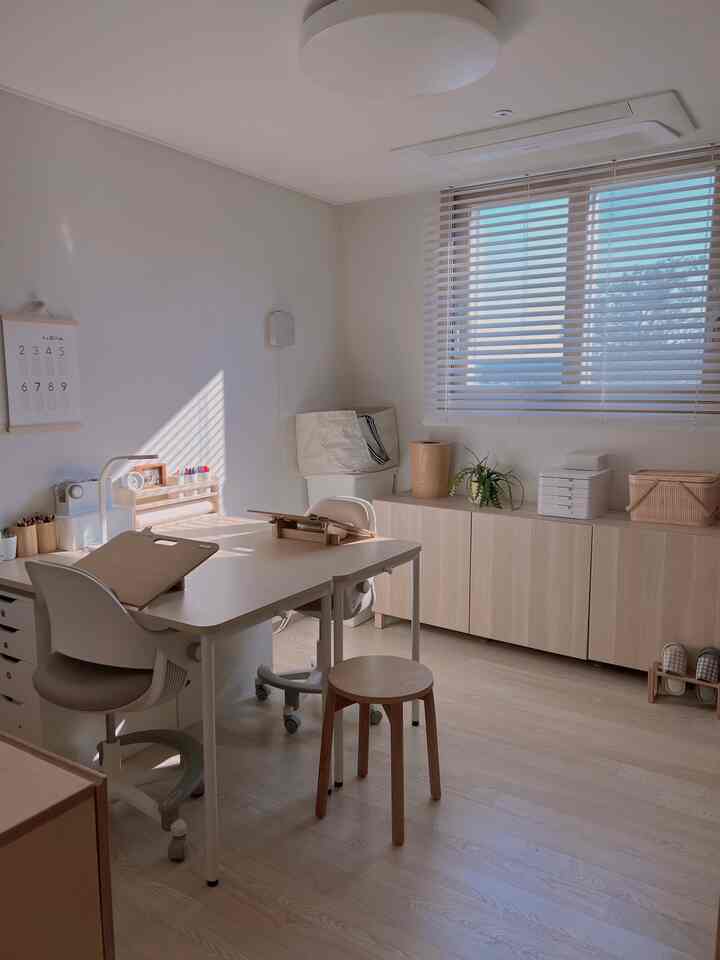 明るいウッドトーンとホワイトを基調とした子供部屋の勉強スペースで、実用的な机と収納家具が配置された印象的な空間