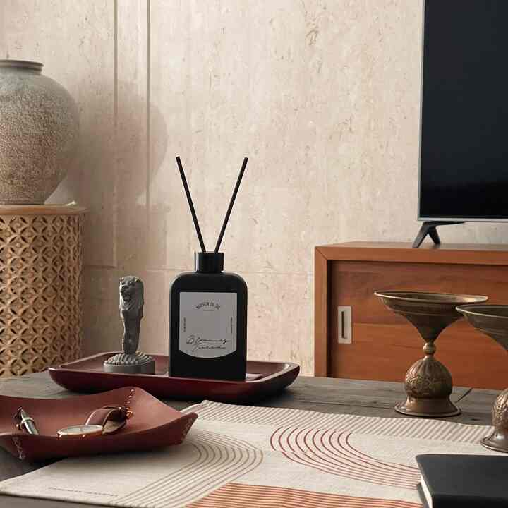 A cozy living room coffee table in brown and wood tones featuring various interior accessories