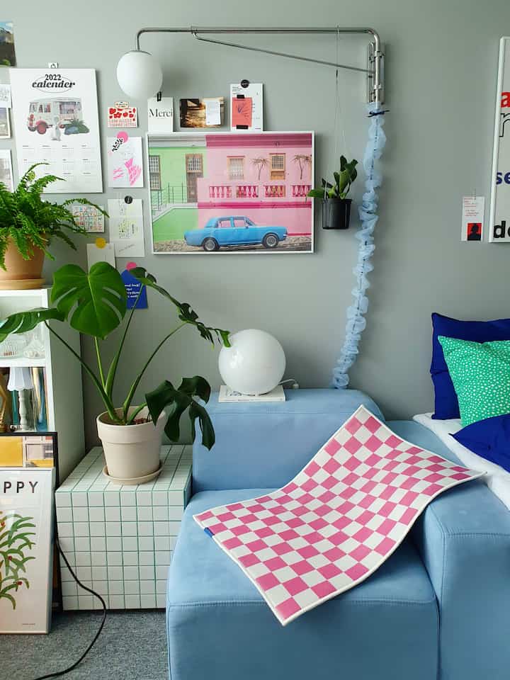 Cozy living room in calm blue and pink tones featuring pastel sofa and lush plants with a soft atmosphere