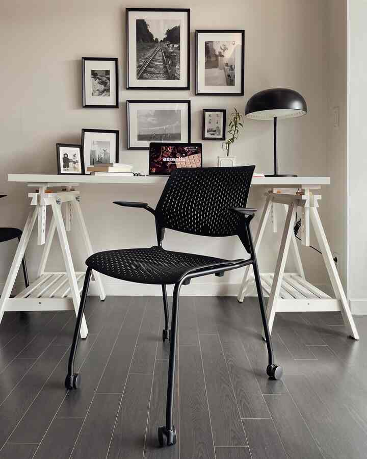 A modern home office in white and black tones featuring a white desk and black office chair in a minimalist workspace