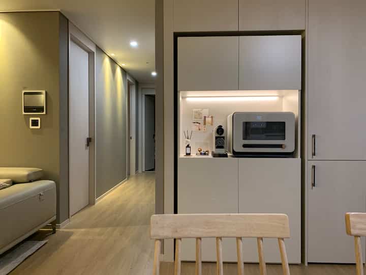 Natural wood tones highlight a kitchen cabinet and home bar area creating a cozy cafe-style atmosphere