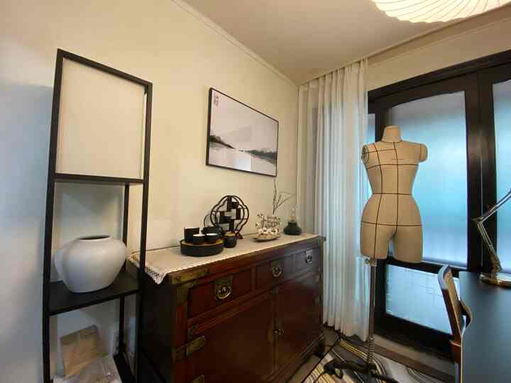 White and black toned study space featuring a traditional dresser and black metal shelving in a modern interior