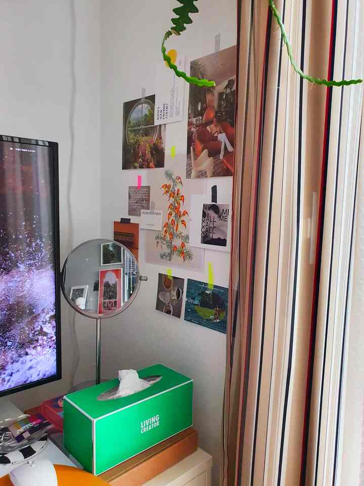 Room with white walls and brown striped curtains, featuring a tabletop mirror and green tissue box on a cozy vanity