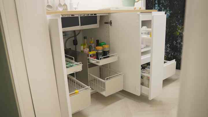 White-toned kitchen space featuring sliding 2-tier storage shelves and organized cabinetry for a modern, practical interior
