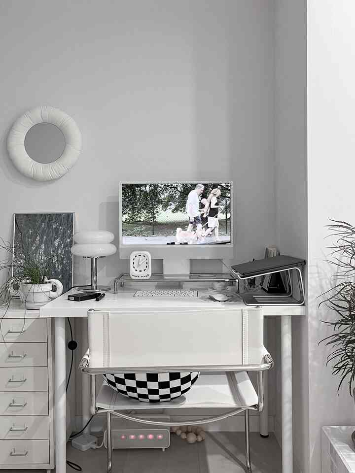 White-toned home office featuring an iMac monitor and a tidy desk creating a simple workspace