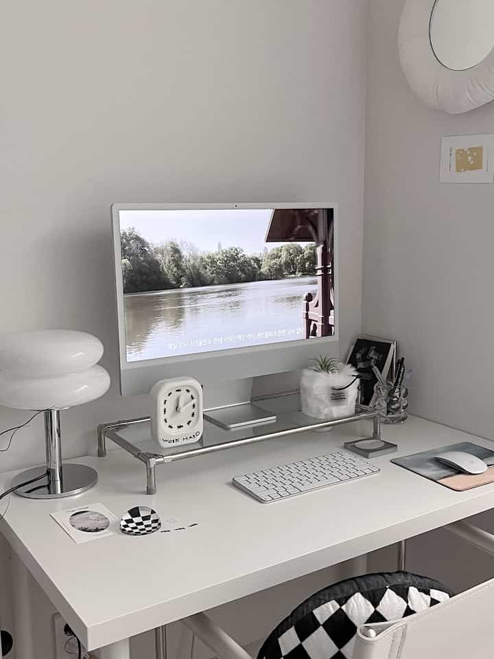 White-toned home office featuring a monitor and desk with a clean and simple workspace atmosphere