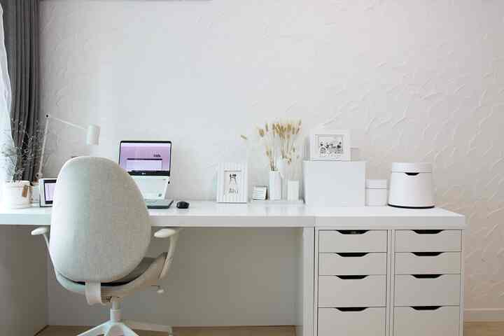 白を基調としたホームオフィス、デスクや収納棚、オフィスチェアが配置されたシンプルでモダンな雰囲気のインテリア