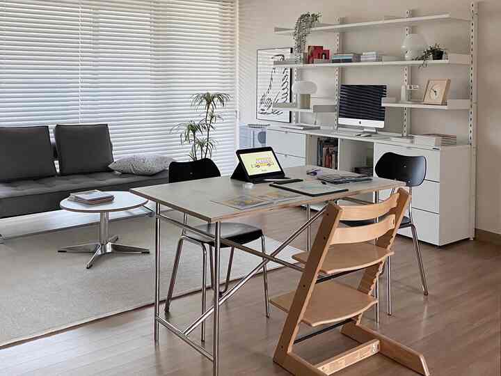 White and wood tone living room study featuring a large desk, shelves, and sofa with a cozy atmosphere