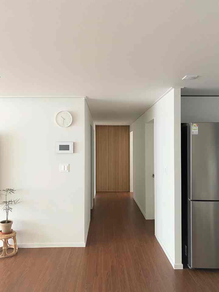 Modern and simple living space featuring white walls and wood tone floors creating a harmonious atmosphere