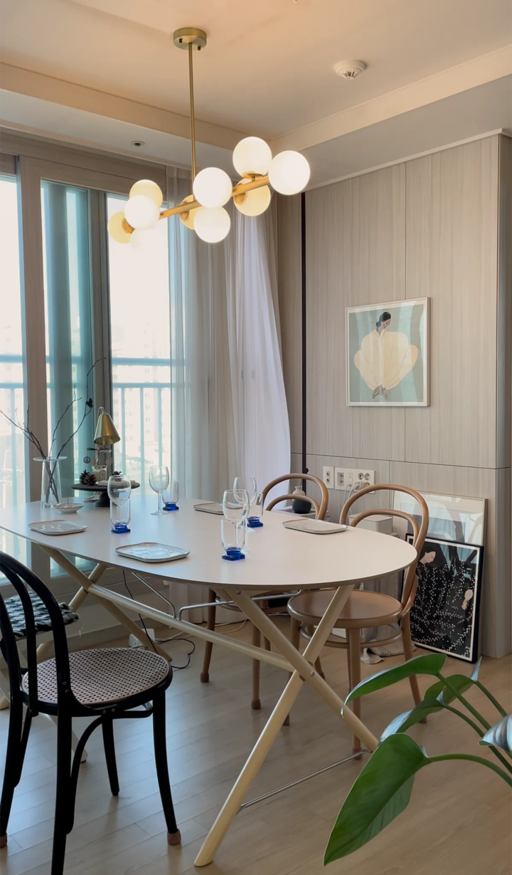 Natural tone wood floor with Nordic style dining table and chairs in a bright cozy dining area