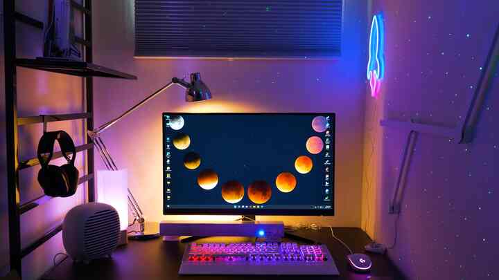 Black-toned compact home office featuring neon lights and LED keyboard creating a futuristic ambiance