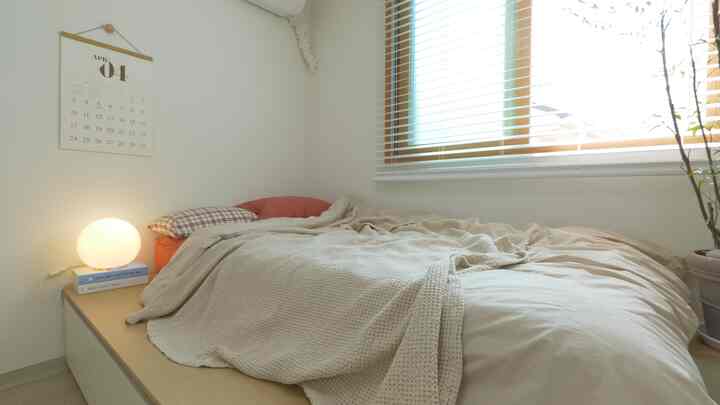 Beige and wood-toned bedroom featuring large storage bed with linen bedding, creating a calm and cozy atmosphere