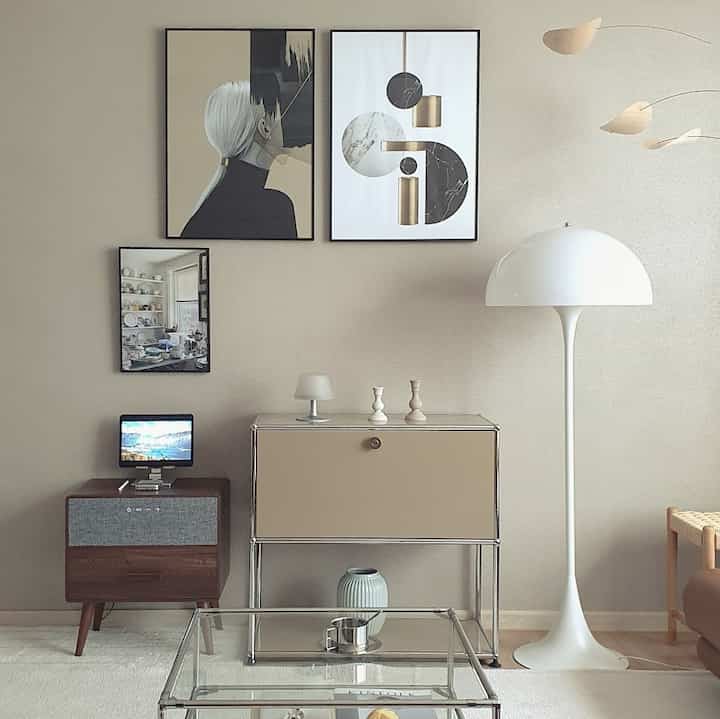 Natural beige-toned living room featuring a console table, floor lamp, and wall art in a modern interior setting