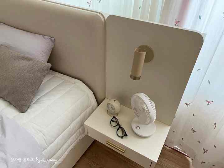 A beige and white toned bedroom featuring a bed and nightstand with a clean modern design