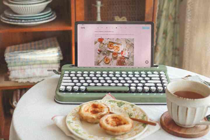Natural wood tones and vintage Bluetooth keyboard on a home cafe table featuring egg tarts and a mug in a cozy setting