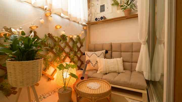 Warm beige and wood-toned veranda featuring rattan table, cushioned sofa, and plants creating a cozy atmosphere
