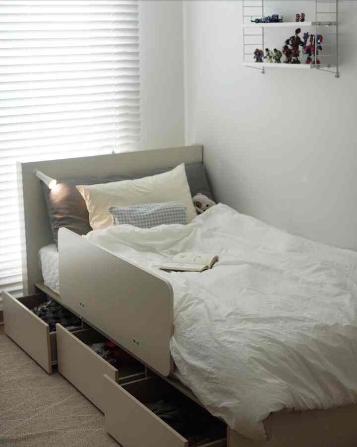 White-toned bedroom featuring a storage bed with clean bedding, creating a neat and minimalist space