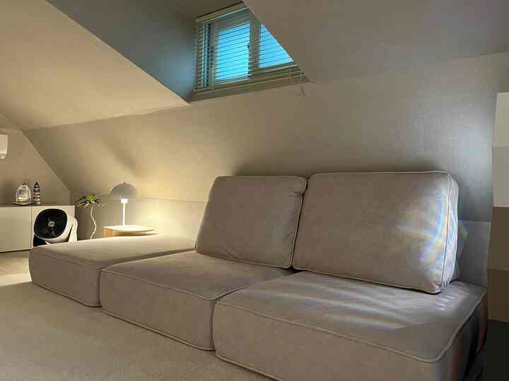 Natural beige and ivory toned living room featuring a wide low seating sofa and white blinds creating a cozy atmosphere