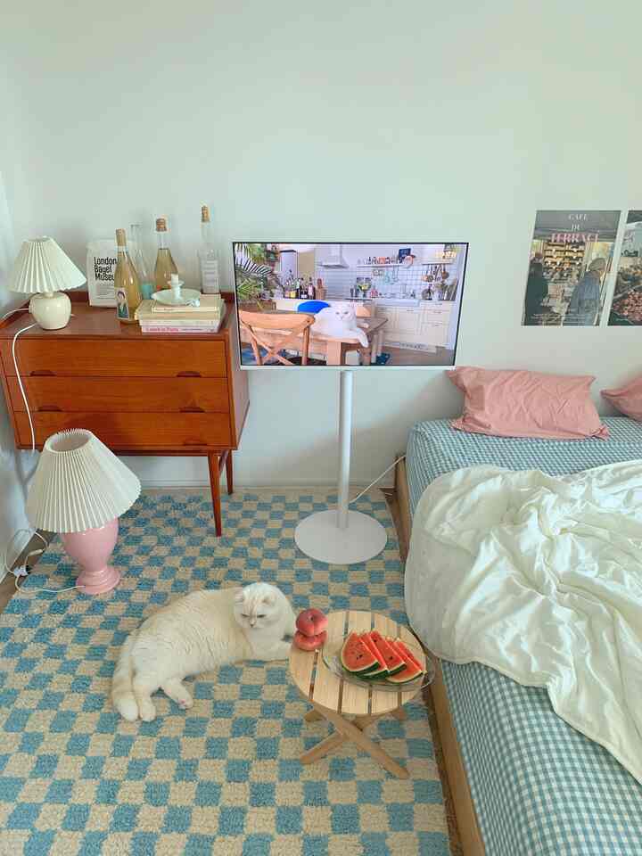 White and blue toned bedroom featuring natural wood furniture and a cozy cat presence