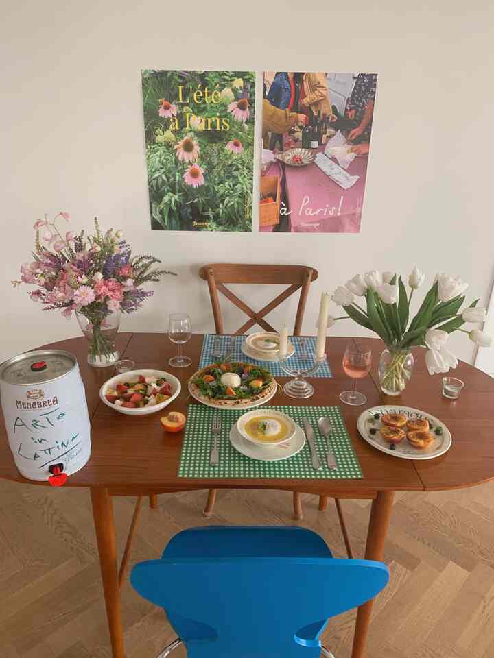 Natural dining room with white walls and brown wooden dining table, featuring floral vases and a cozy home party setup