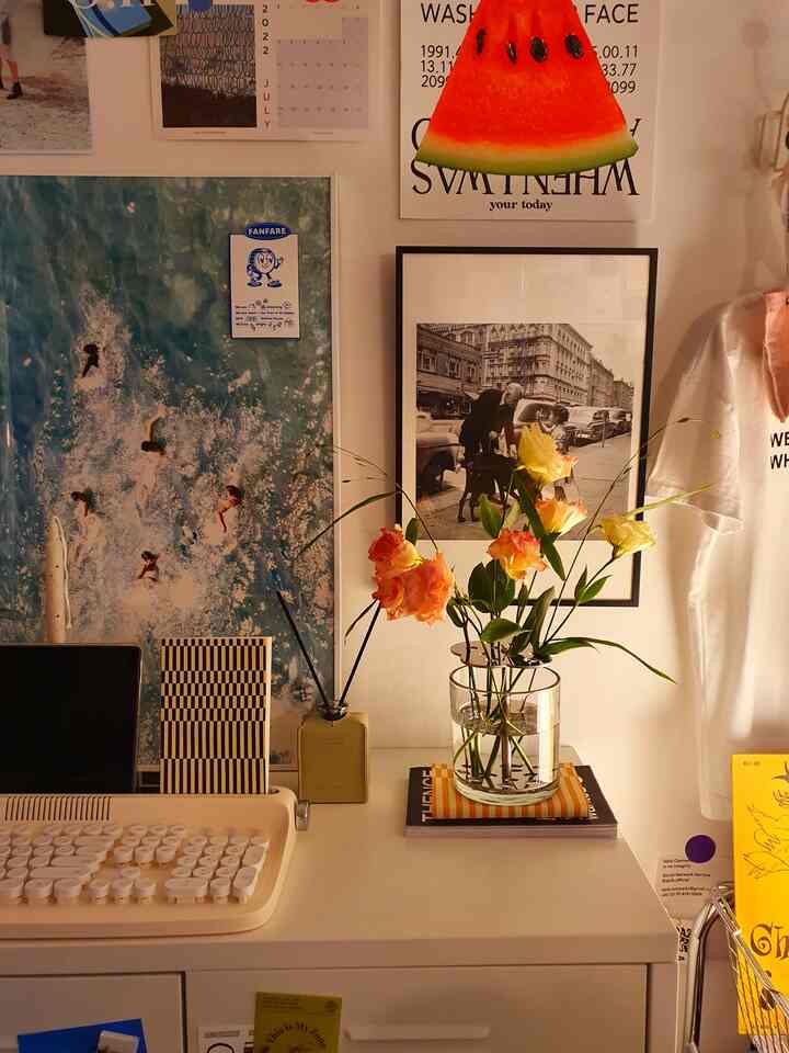 Warm ivory-toned small home office featuring a desk with a vase of flowers and simple framed artwork creating a cozy atmosphere