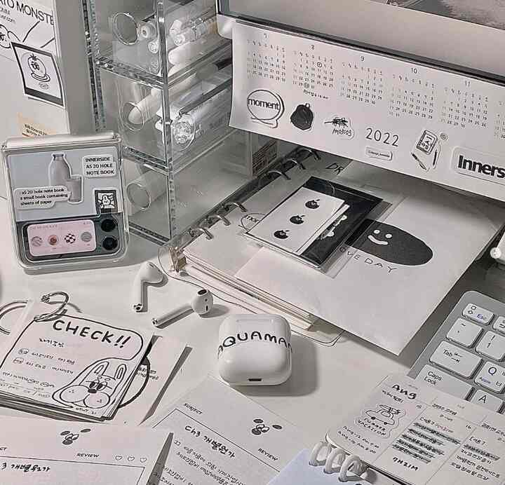 ホワイトとグレーのモノトーンのデスクとアクリル収納が配置されたシンプルな書斎空間