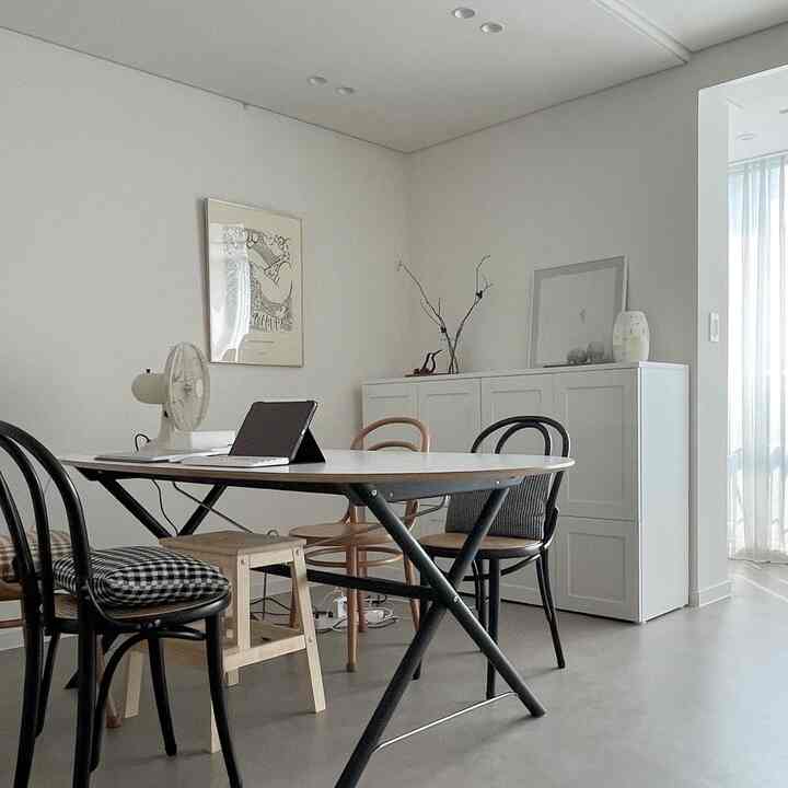 White and black toned dining room featuring simple dining table, chairs, and framed wall art with a calm atmosphere