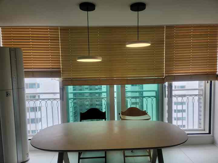 Beige and wood tone kitchen dining area featuring large dining table, two chairs, and pendant lights creating a clean atmosphere
