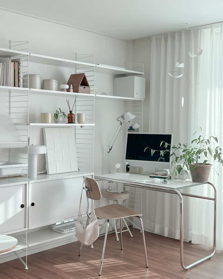 Bright white and brown wood-tone study-style home office featuring a sleek desk, chair, shelving, and a potted plant