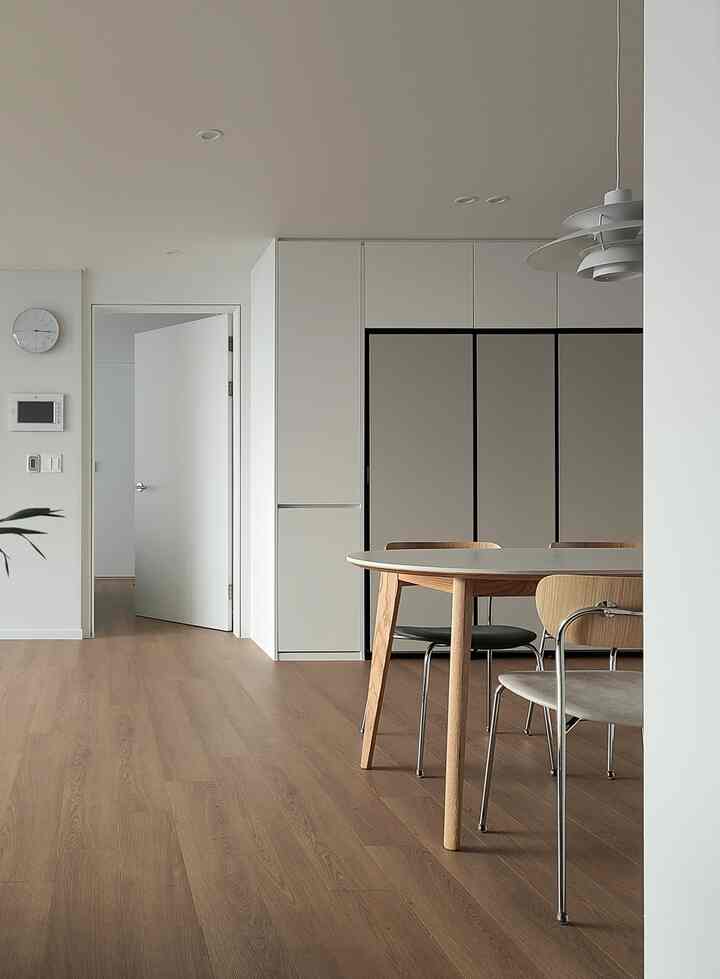 White and brown tone kitchen dining room featuring natural wood dining table and chairs with a modern vibe