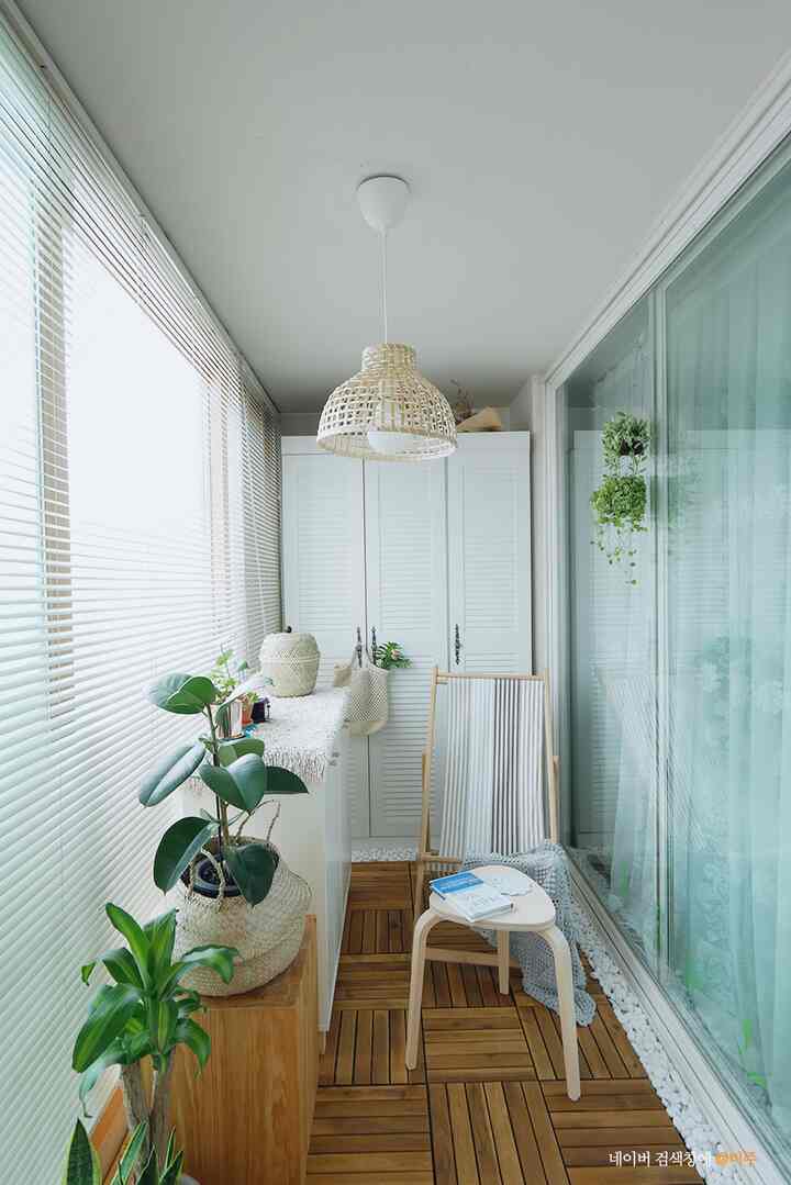 Natural styled veranda with white walls and wood tone flooring, featuring plants and storage cabinets creating a cozy atmosphere