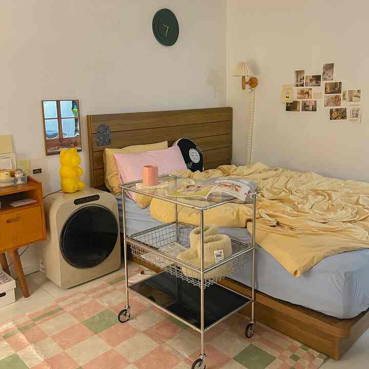 Cozy bedroom with beige and wood tones featuring a bed and a storage cart creating a comfortable atmosphere
