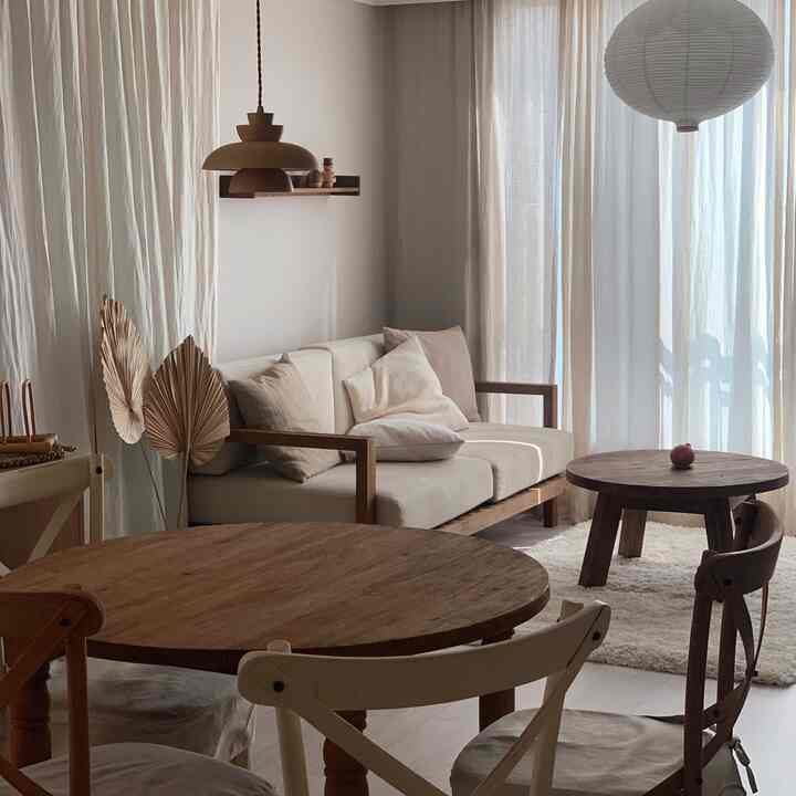 ブラウンの木目調とアイボリーのリネンが調和したリビングとキッチンが繋がるナチュラルなインテリア