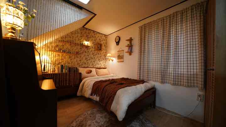 Cozy 2-pyeong bedroom featuring vintage floral wallpaper and wood tone furniture