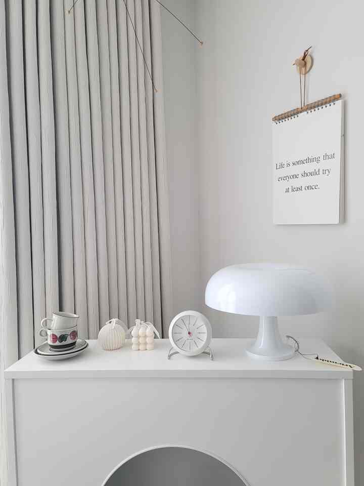 White and natural-toned space featuring curtains and minimalistic decor with a clean and calm atmosphere