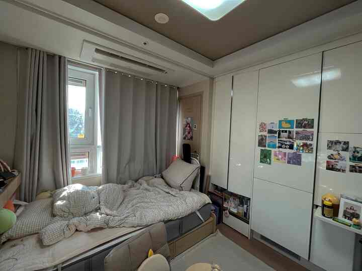 Beige and white toned 6-tatami bedroom featuring cream curtains and large closet in a cozy single household space